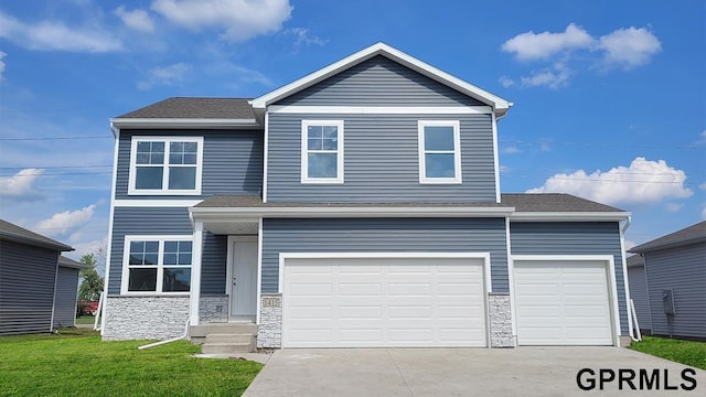 view of front of home featuring a front yard and a garage