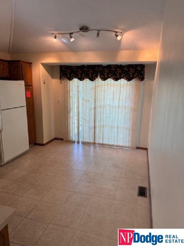 spare room with a textured ceiling and rail lighting