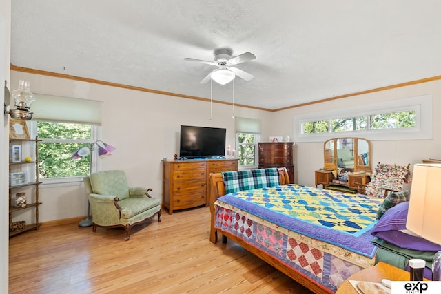 bedroom featuring ornamental molding, light hardwood / wood-style flooring, a textured ceiling, and ceiling fan