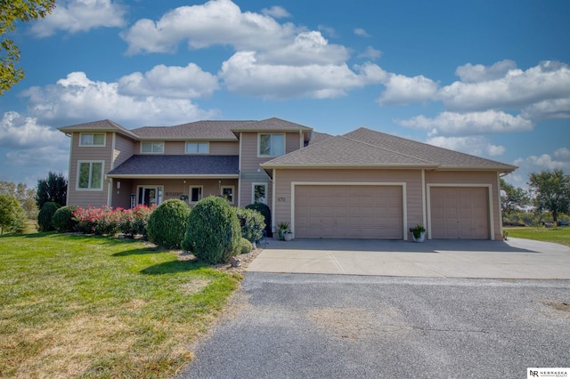 prairie-style house featuring concrete driveway, a front lawn, a shingled roof, and a garage
