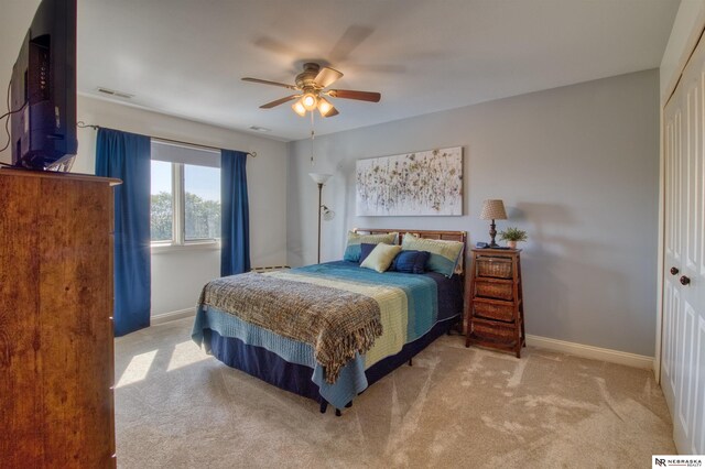 carpeted bedroom featuring ceiling fan and a closet