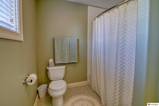 bathroom with toilet and a shower with curtain