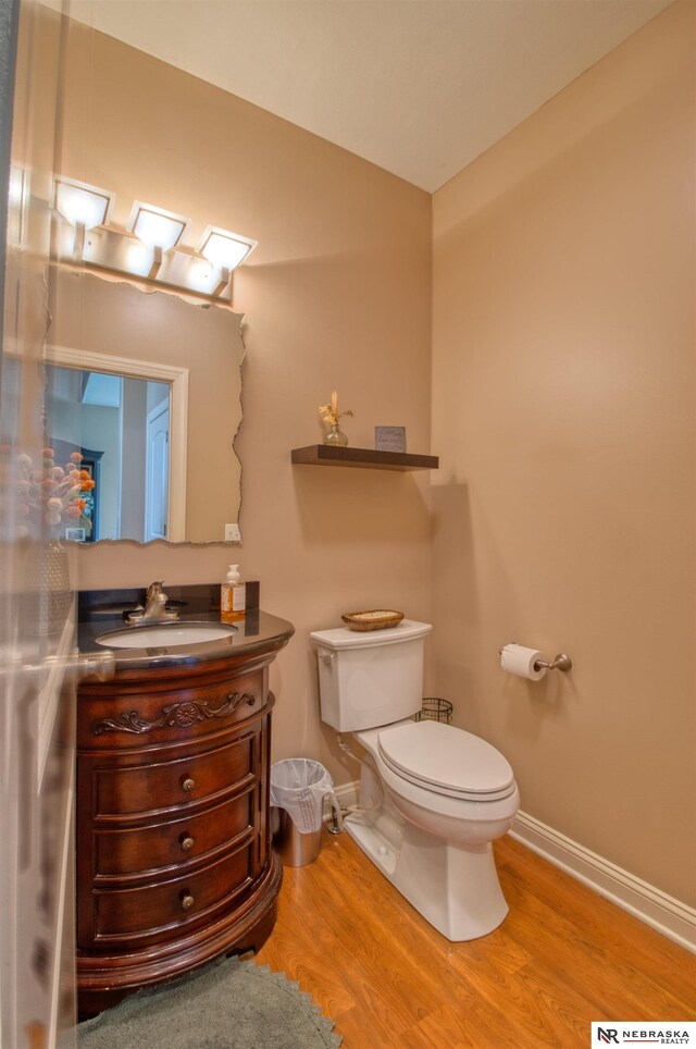 bathroom featuring wood-type flooring, vanity, and toilet