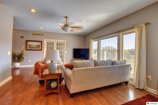 living room with wood-type flooring and ceiling fan