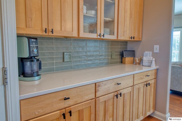 kitchen featuring light wood-type flooring, light brown cabinets, and tasteful backsplash