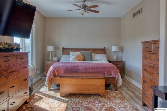 bedroom with light hardwood / wood-style floors and ceiling fan