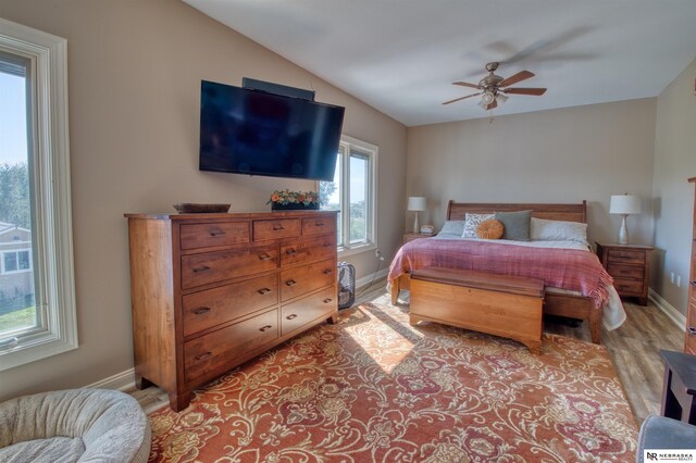 bedroom featuring ceiling fan, vaulted ceiling, and light hardwood / wood-style floors