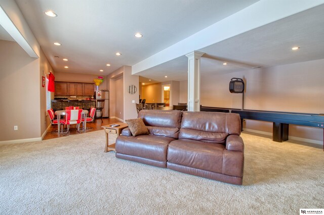 carpeted living room with decorative columns