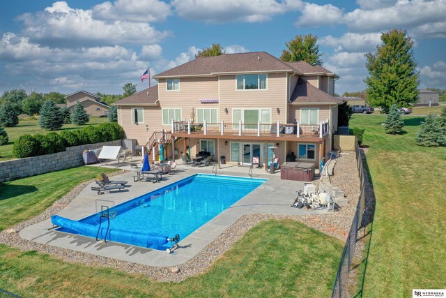 view of swimming pool with a hot tub, a patio area, and a yard