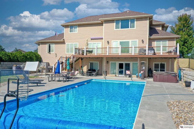 exterior space featuring a deck, a patio area, and a hot tub