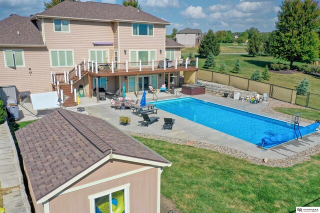 view of swimming pool with a yard, a patio, and a hot tub