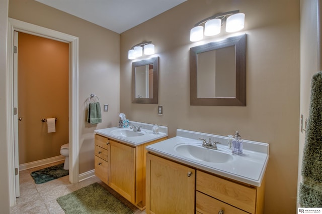 bathroom with tile patterned flooring, vanity, and toilet