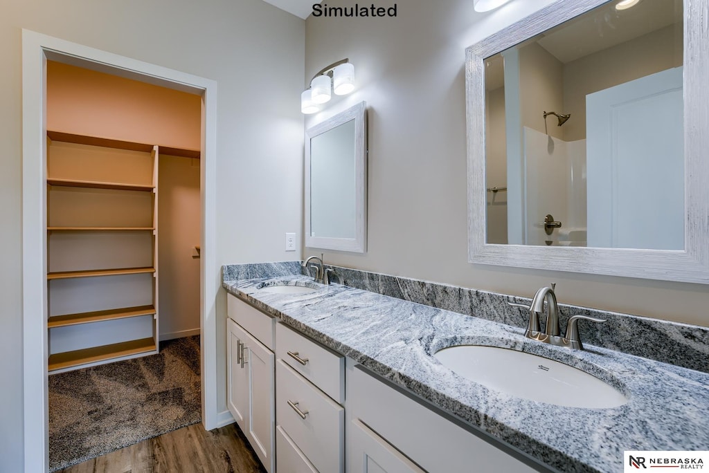 bathroom with walk in shower, hardwood / wood-style flooring, and vanity