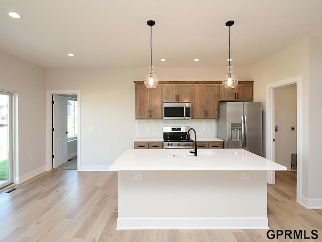 kitchen featuring an island with sink, appliances with stainless steel finishes, and light hardwood / wood-style floors