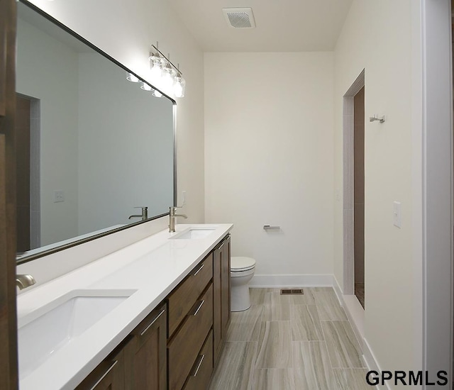 bathroom with vanity, a shower, and toilet