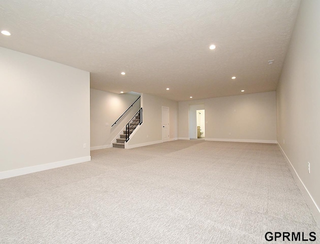 carpeted empty room with a textured ceiling