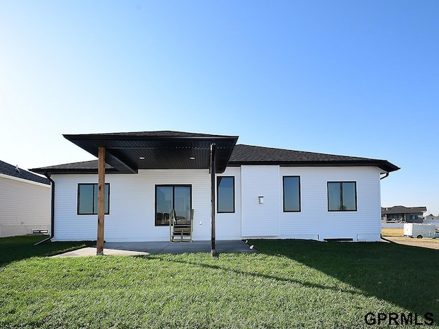 rear view of property with a yard and a patio area