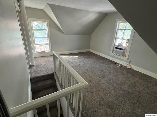 bonus room featuring a textured ceiling, cooling unit, lofted ceiling, and carpet floors