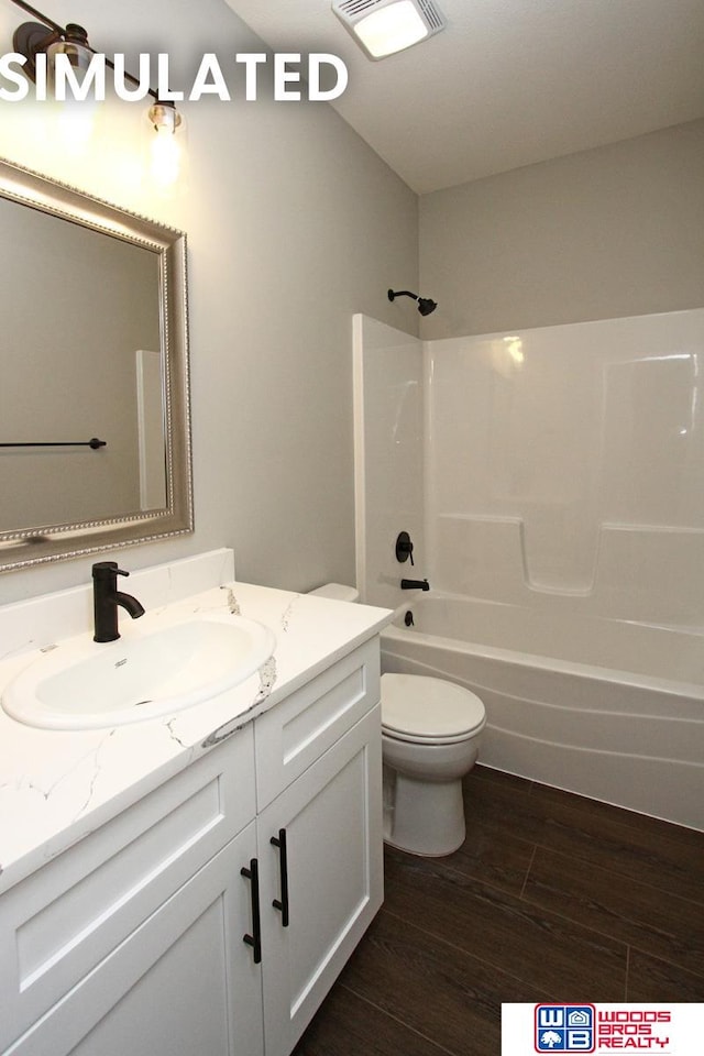 full bathroom with bathtub / shower combination, vanity, hardwood / wood-style flooring, and toilet