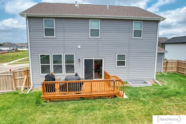 rear view of house with a lawn and a wooden deck