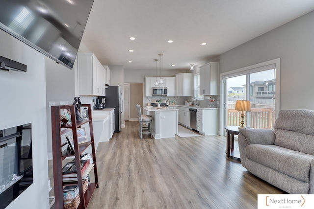 living room featuring sink and light hardwood / wood-style flooring