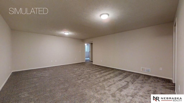 spare room with a textured ceiling and dark colored carpet