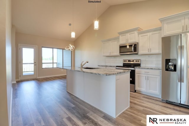 kitchen featuring white cabinets, an island with sink, hanging light fixtures, stainless steel appliances, and light hardwood / wood-style floors