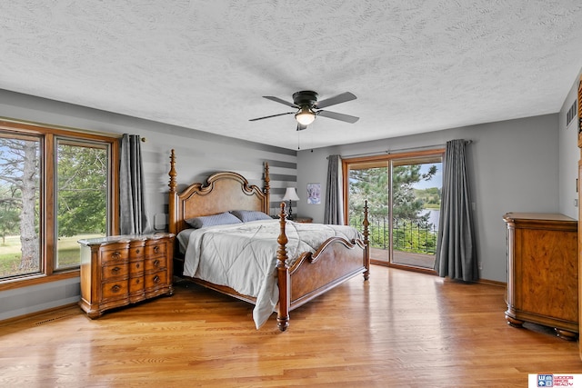 bedroom featuring ceiling fan, light wood-type flooring, and multiple windows