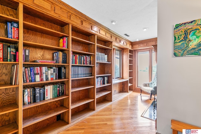 interior space featuring light wood-type flooring and wood walls