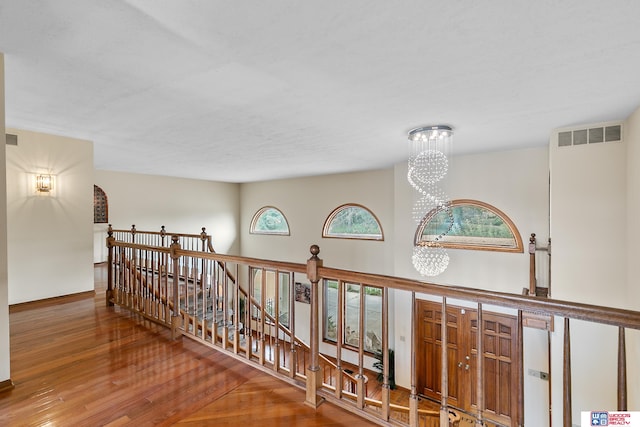 corridor featuring a chandelier and hardwood / wood-style flooring