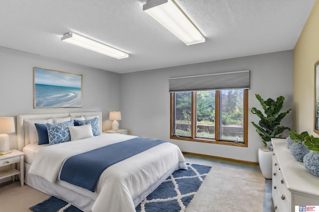 bedroom featuring a textured ceiling and light colored carpet