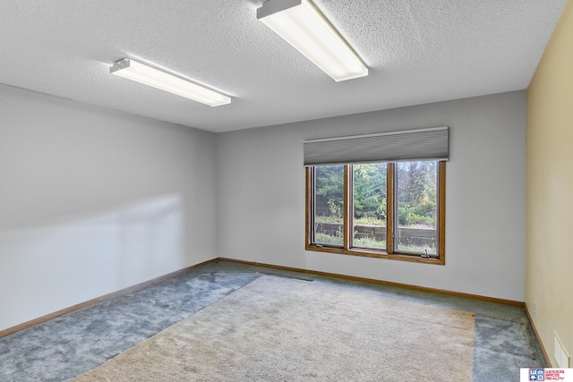 spare room featuring a textured ceiling and carpet