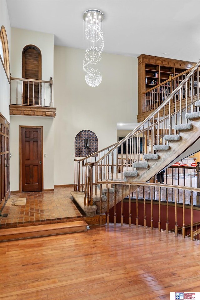 staircase with a notable chandelier and hardwood / wood-style flooring