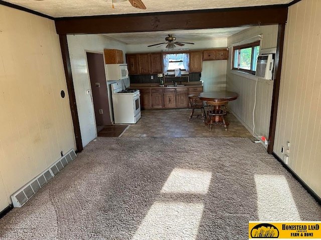 kitchen featuring ceiling fan, dark colored carpet, white appliances, and a wealth of natural light