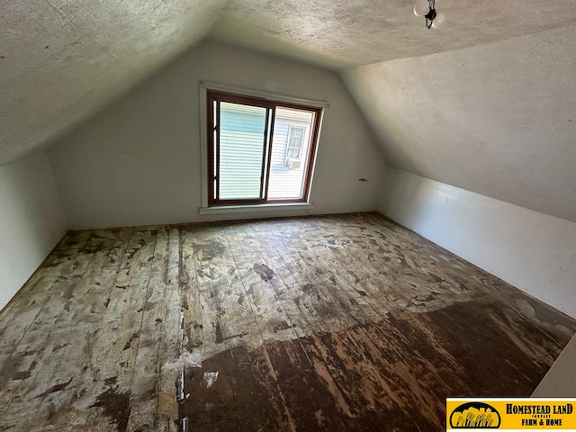 bonus room with vaulted ceiling, a textured ceiling, and hardwood / wood-style floors