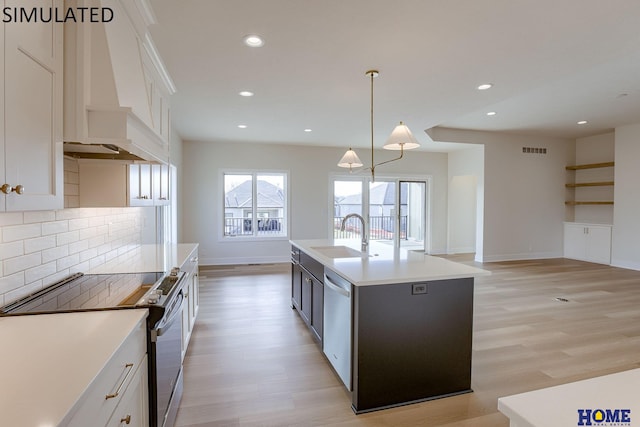 kitchen with an island with sink, white cabinets, appliances with stainless steel finishes, and sink