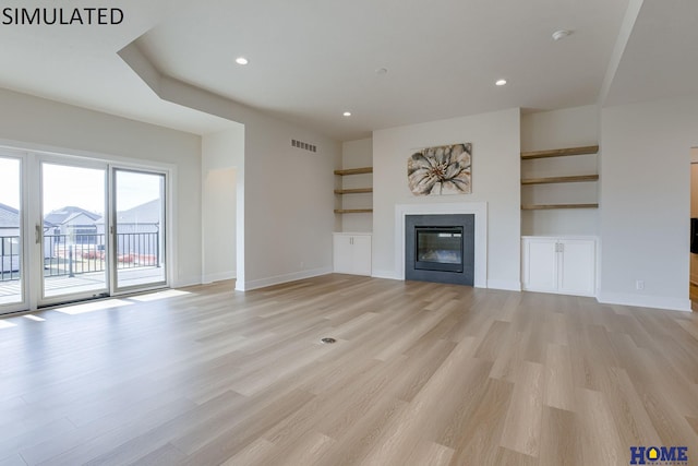 unfurnished living room featuring light hardwood / wood-style floors and built in features