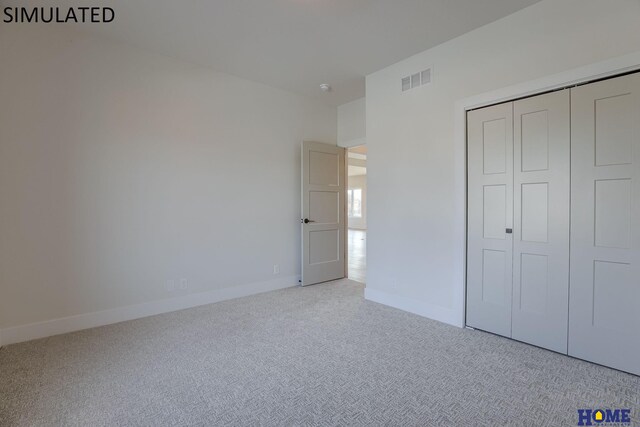 unfurnished bedroom featuring a closet and light colored carpet