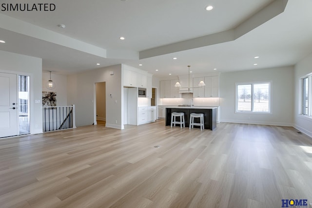 unfurnished living room featuring light wood-type flooring and sink