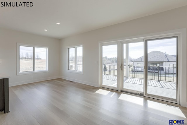 unfurnished living room featuring a healthy amount of sunlight and light hardwood / wood-style flooring