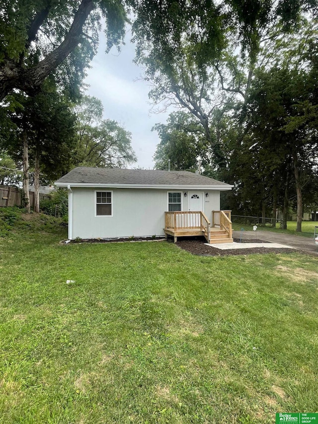 view of front of property featuring a front yard and a deck