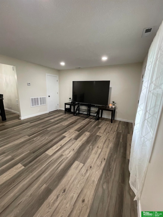 living room featuring a textured ceiling and dark hardwood / wood-style floors