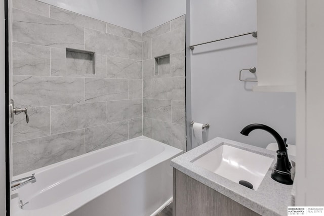 bathroom with vanity and tiled shower / bath combo