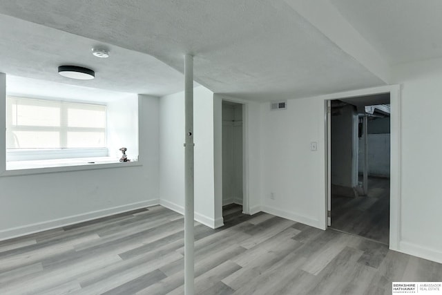 interior space with a textured ceiling and light wood-type flooring