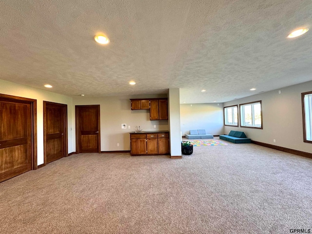 unfurnished living room with a textured ceiling and carpet flooring