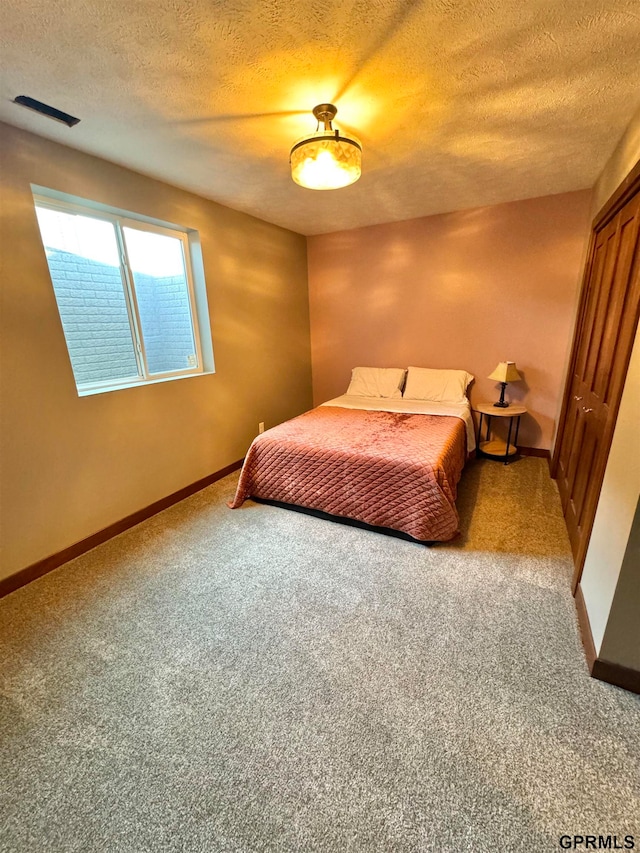 bedroom featuring a textured ceiling and carpet