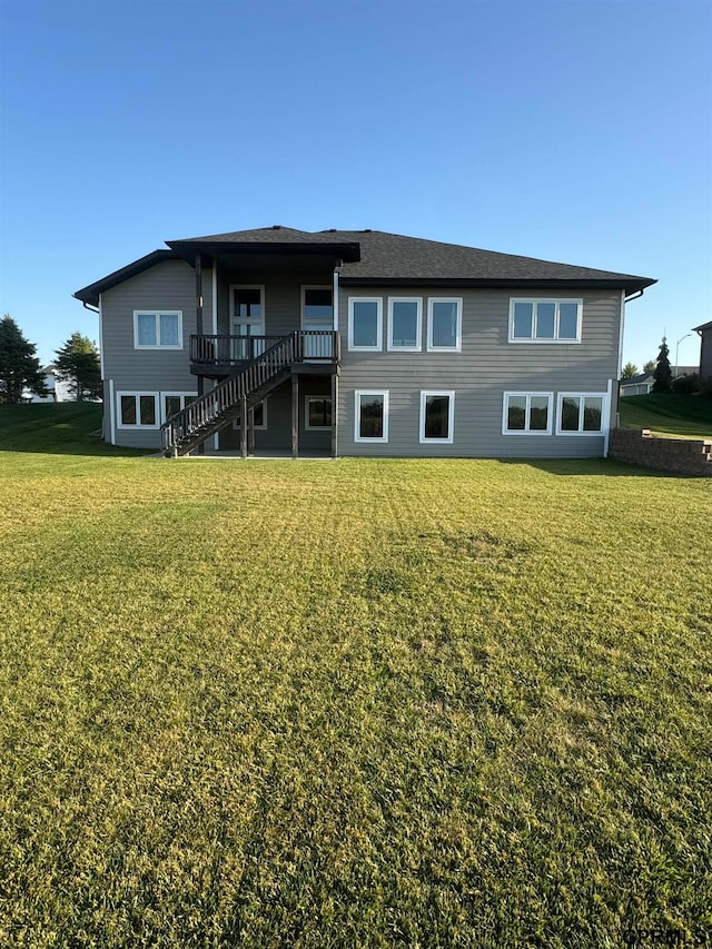 rear view of property featuring a lawn