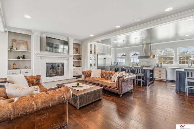 living room featuring ornamental molding, built in features, and dark hardwood / wood-style flooring