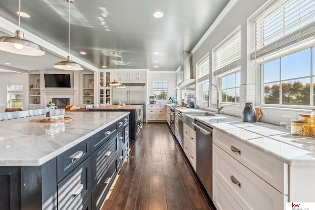 kitchen featuring a wealth of natural light, white cabinetry, stainless steel appliances, and dark hardwood / wood-style flooring