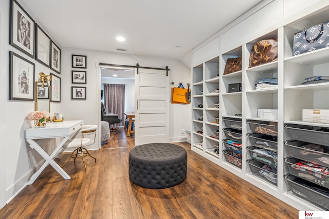 interior space with a barn door and dark hardwood / wood-style floors